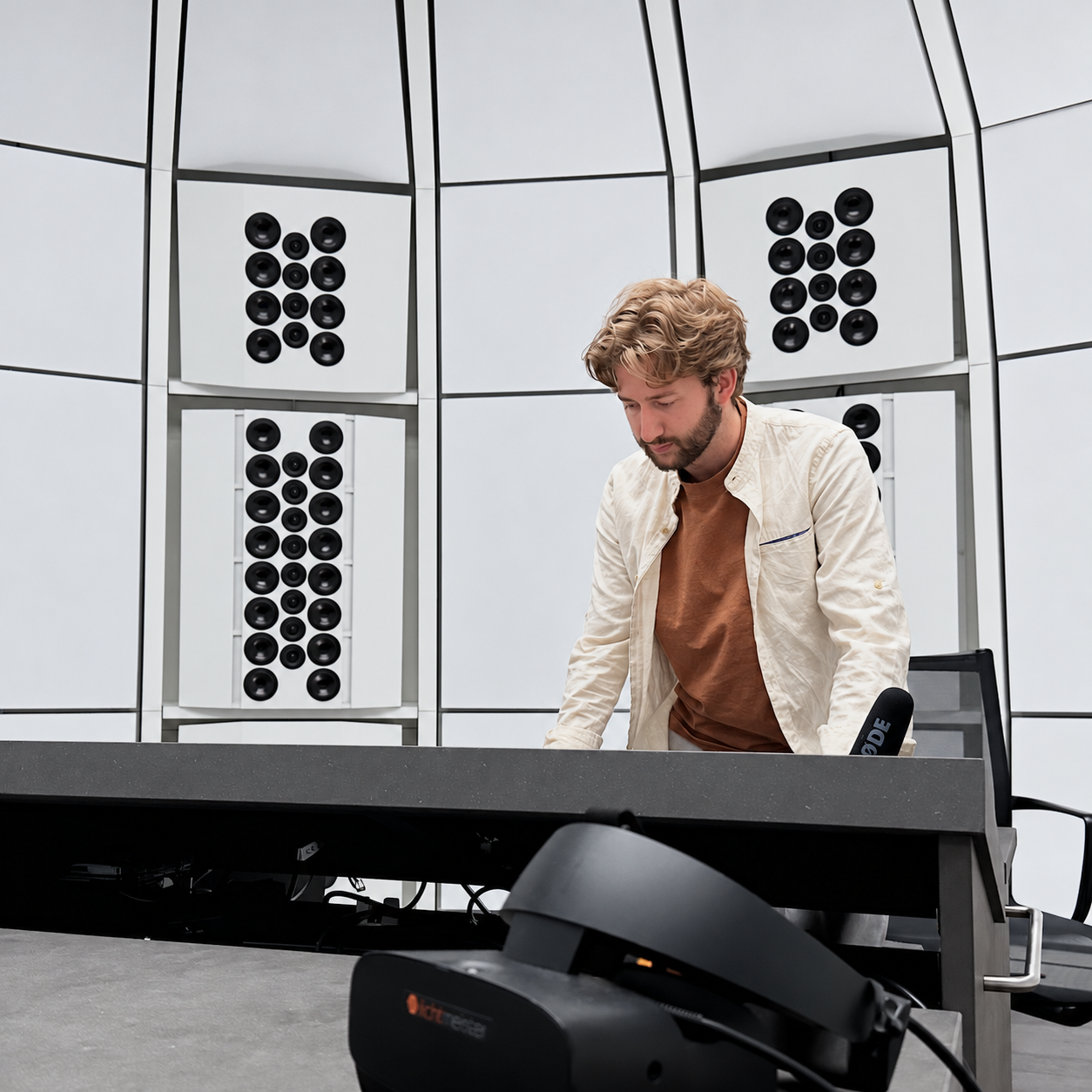 Marc Warner im Tonstudio vor einer Lautsprecherwand